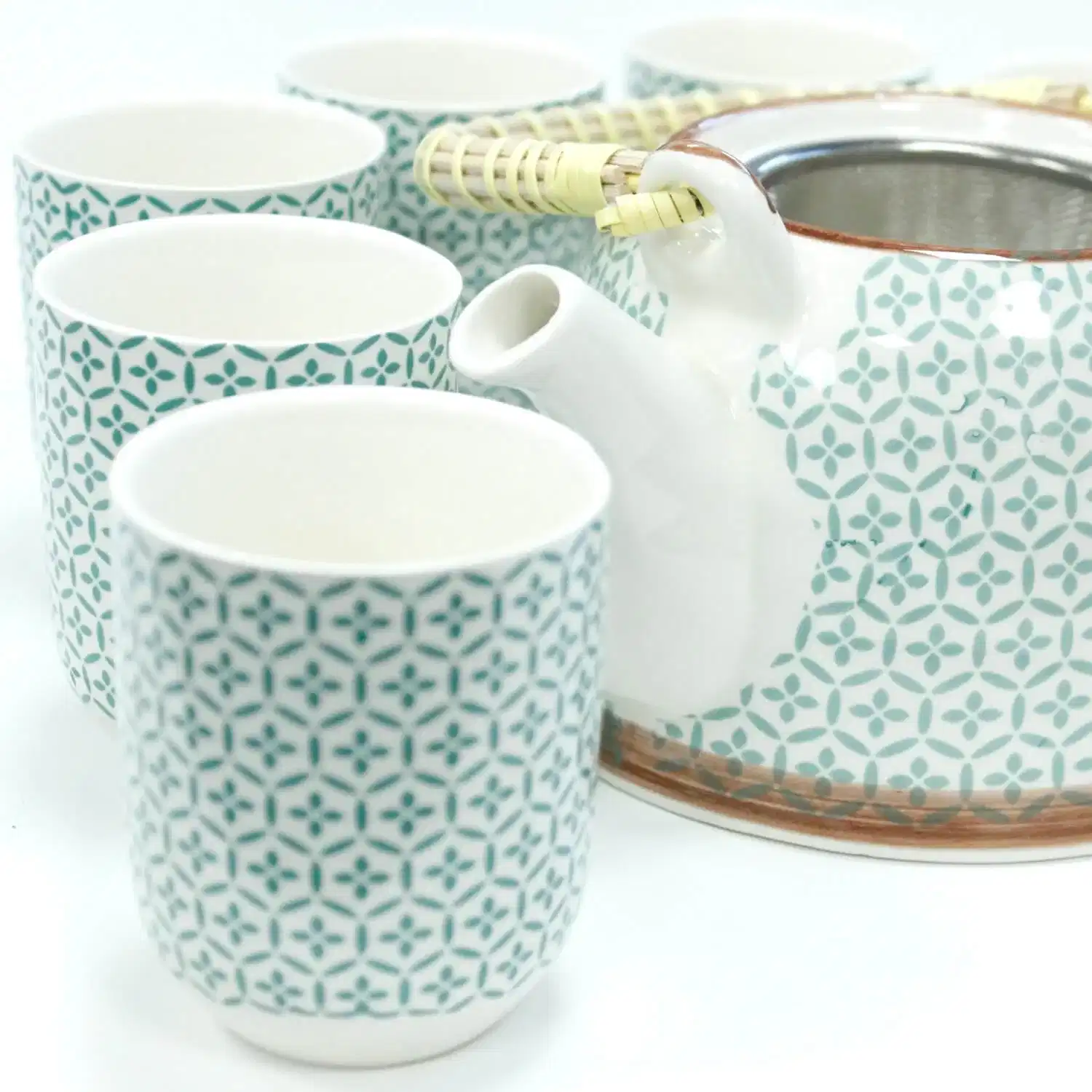 A patterned ceramic teapot with a handle and five matching cups arranged around it, all on a white background.
