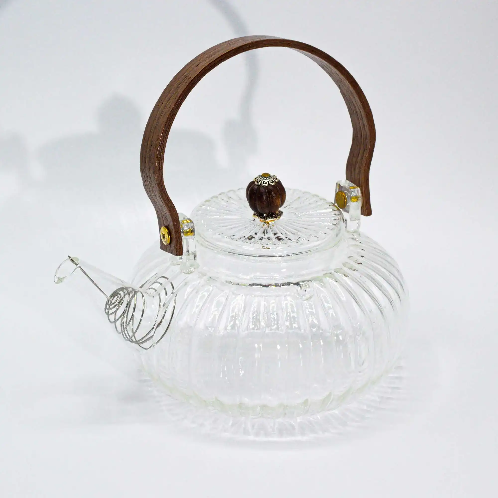 Clear glass teapot with a ribbed design, wooden handle, and wooden knob on the lid, displayed on a white background.