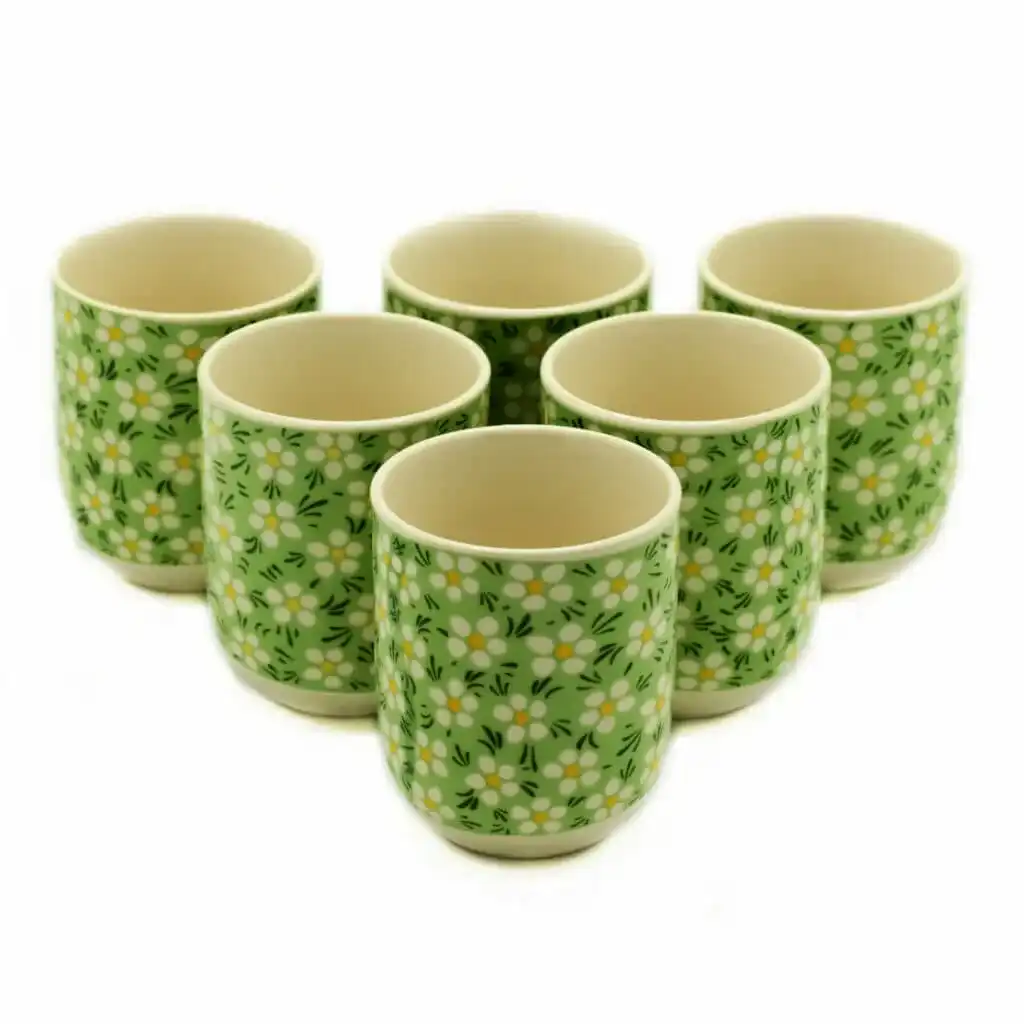 Six ceramic cups with a green background and white floral pattern, arranged in two rows on a white surface.