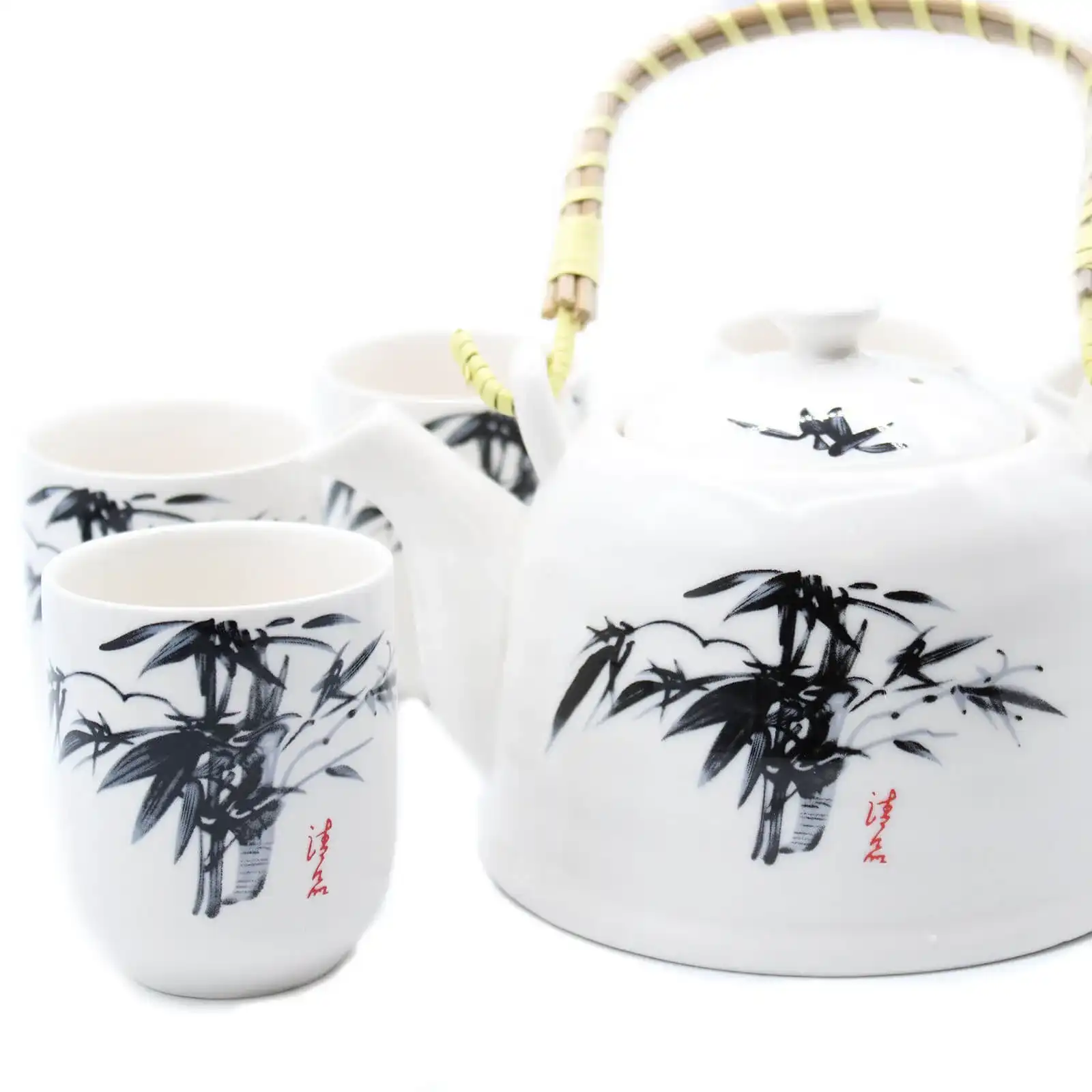 A white ceramic teapot with a bamboo handle and matching cups, all decorated with black bamboo illustrations and red Chinese characters, displayed on a white background.