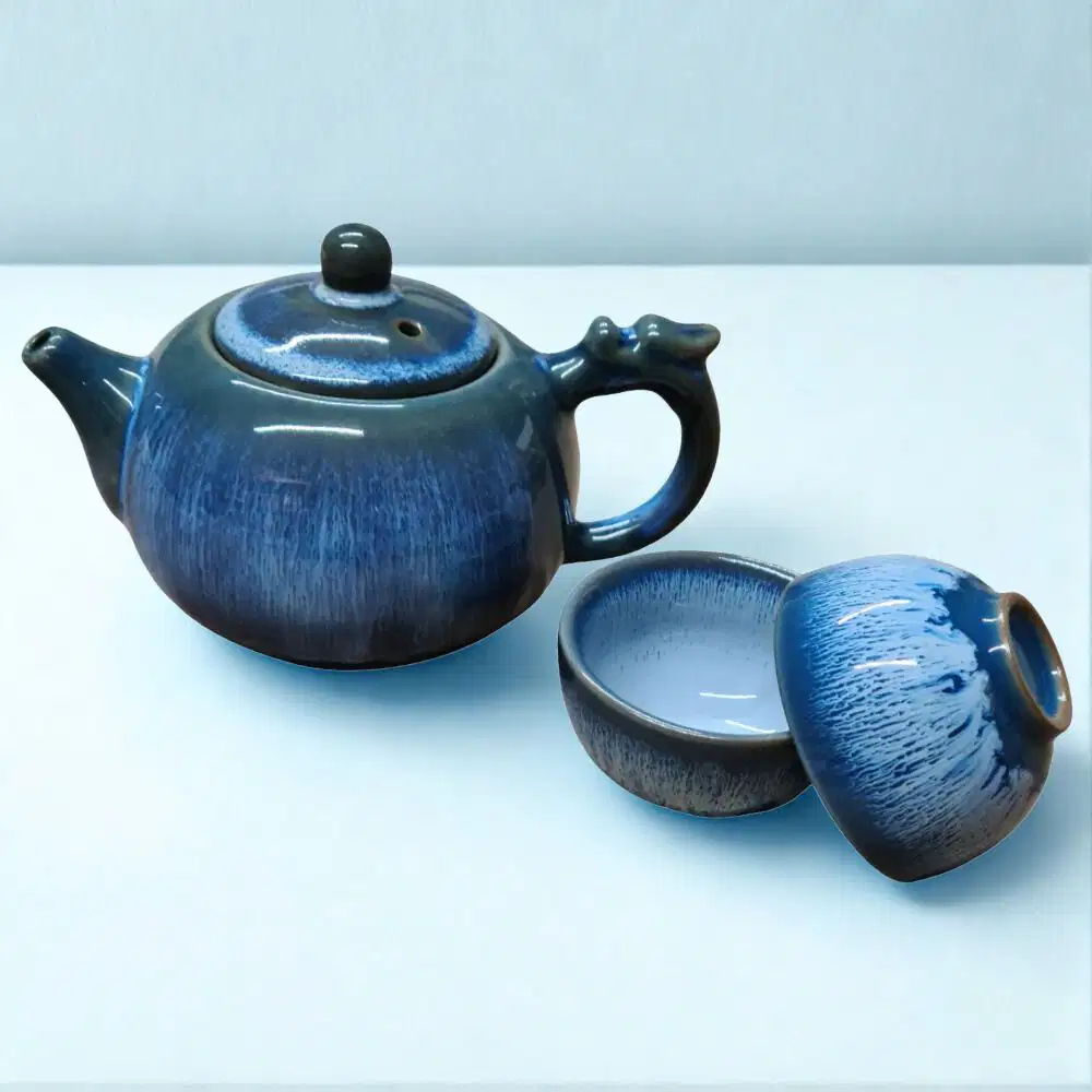 The Ocean Blue Teapot for One | Aqua Teal Tea Set with 2 Cups, featuring a ceramic teapot and matching cups in a blue gradient glaze, is displayed on a plain white surface.