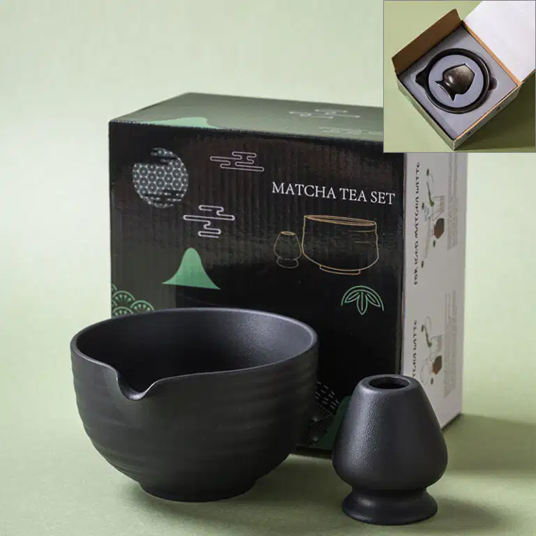 The Matte Matcha Bowl & Whisk Holder Set – 2 Piece | Matte Black is shown in front of its packaging, with an inset highlighting the set neatly arranged inside the box.