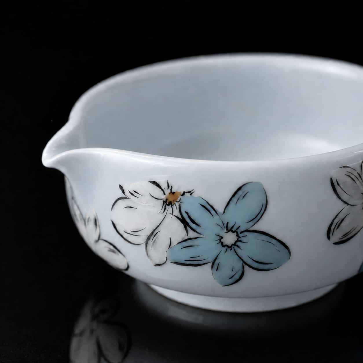 White ceramic jug with blue and white floral designs, displayed against a black background—perfect as an elegant companion to your Blossom Matcha or as part of a charming Matcha Bowl and Whisk Gift Set.