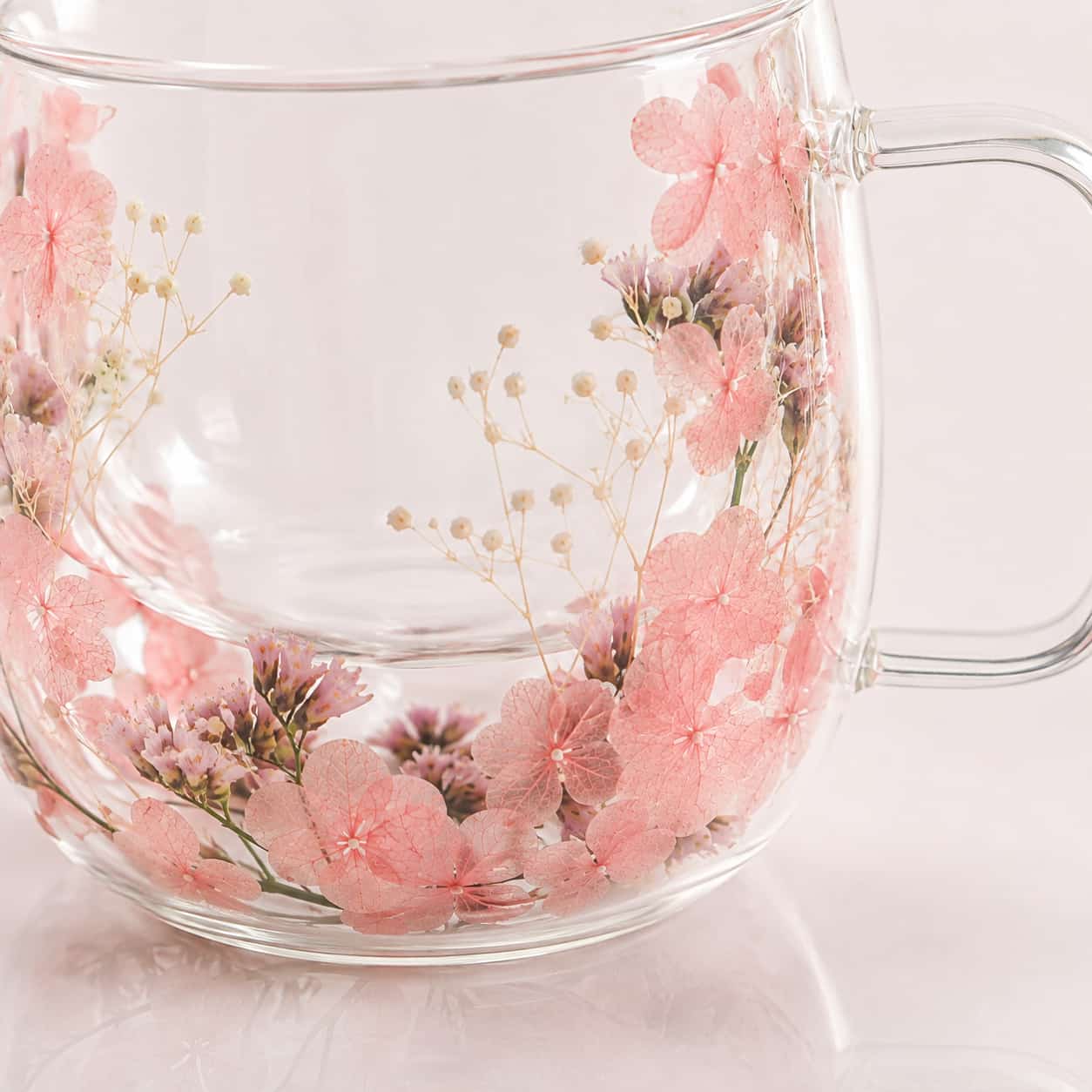 Set of 2 Pressed Flower Double-Walled Tea Glasses (400ml), featuring clear glass with pink and white pressed flowers on a light pink background.