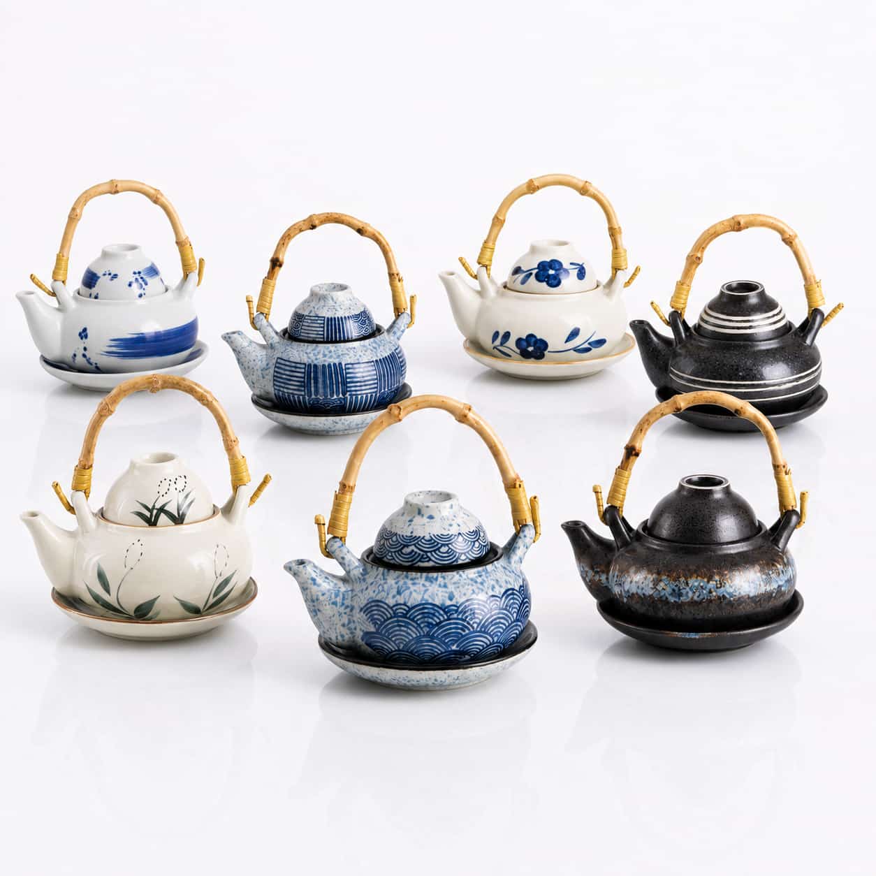 Seven 300ml Ceramic Teapot, Cup & Saucer Sets with bamboo handles—each showcasing unique patterns and vibrant colors—are displayed in two rows against a white background. The teapots hold 300ml each, making them ideal for enjoying your favorite tea with the matching cup and saucer set.