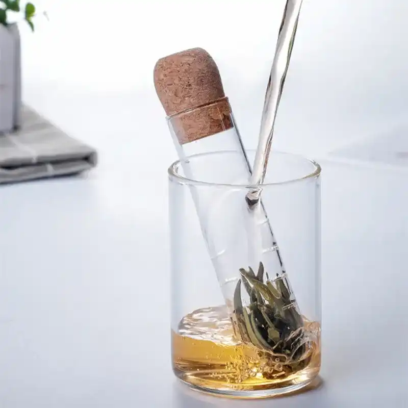 Pour liquid into a glass with a corked test tube holding tea leaves for a Crystal Infuser Pro experience.