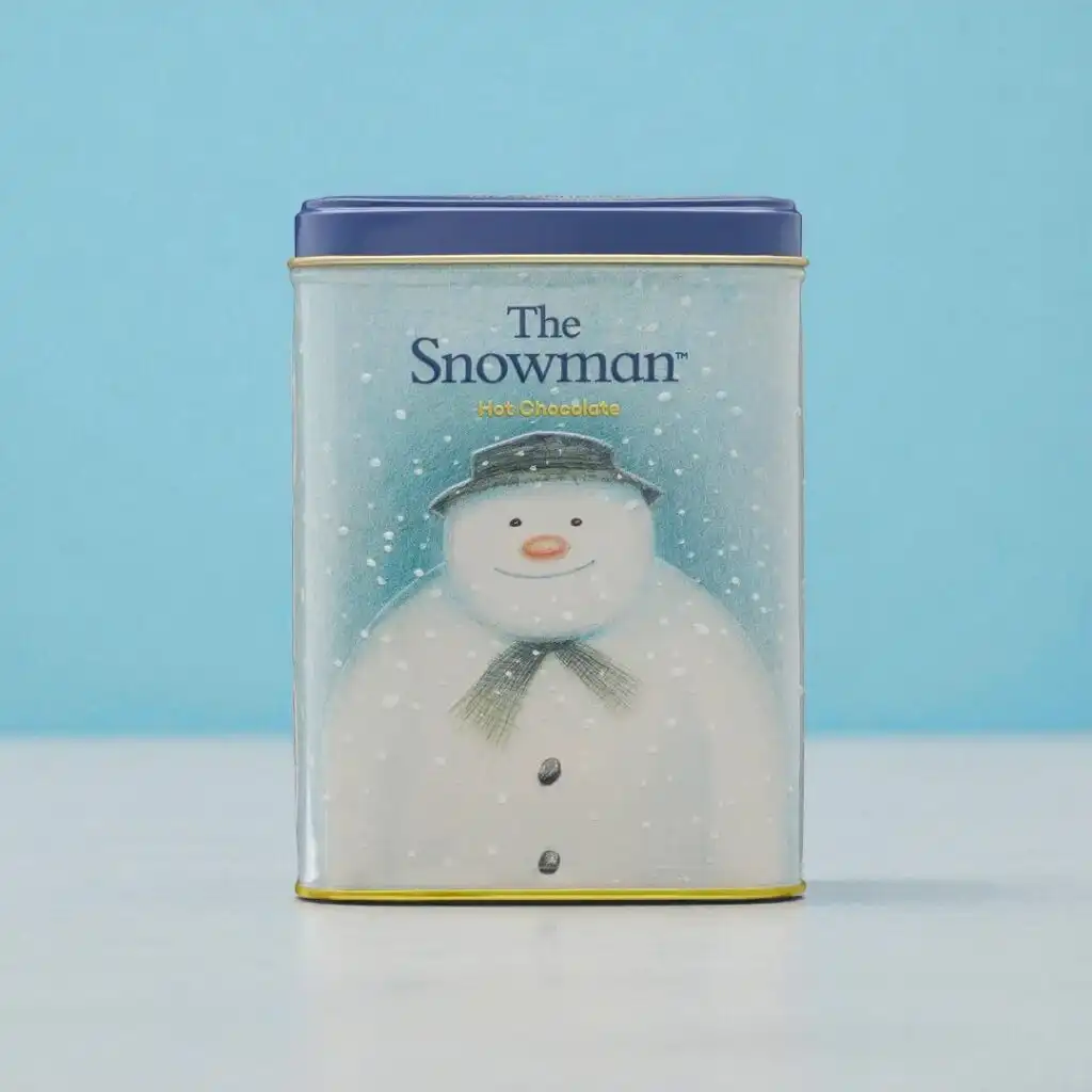A rectangular tin with a blue lid features an illustration of a snowman wearing a hat and scarf, labeled 