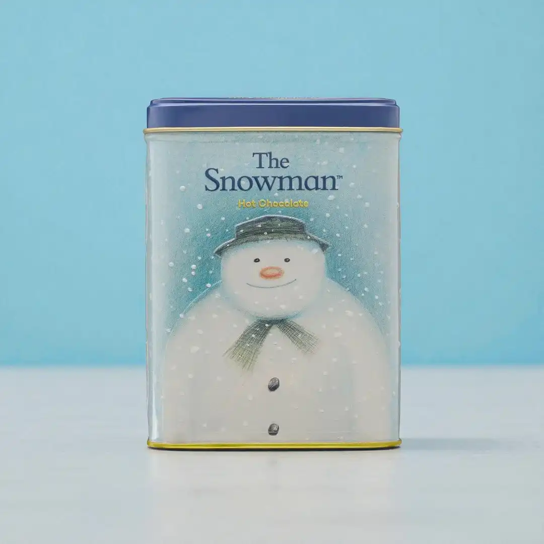 A rectangular tin with a blue lid features an illustration of a snowman wearing a hat and scarf, labeled