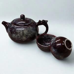 The Ocean Blue Teapot for One is an aqua teal tea set with 2 cups, featuring a glossy marbled finish and round lid, inspired by ocean hues, and elegantly displayed on a plain white background.